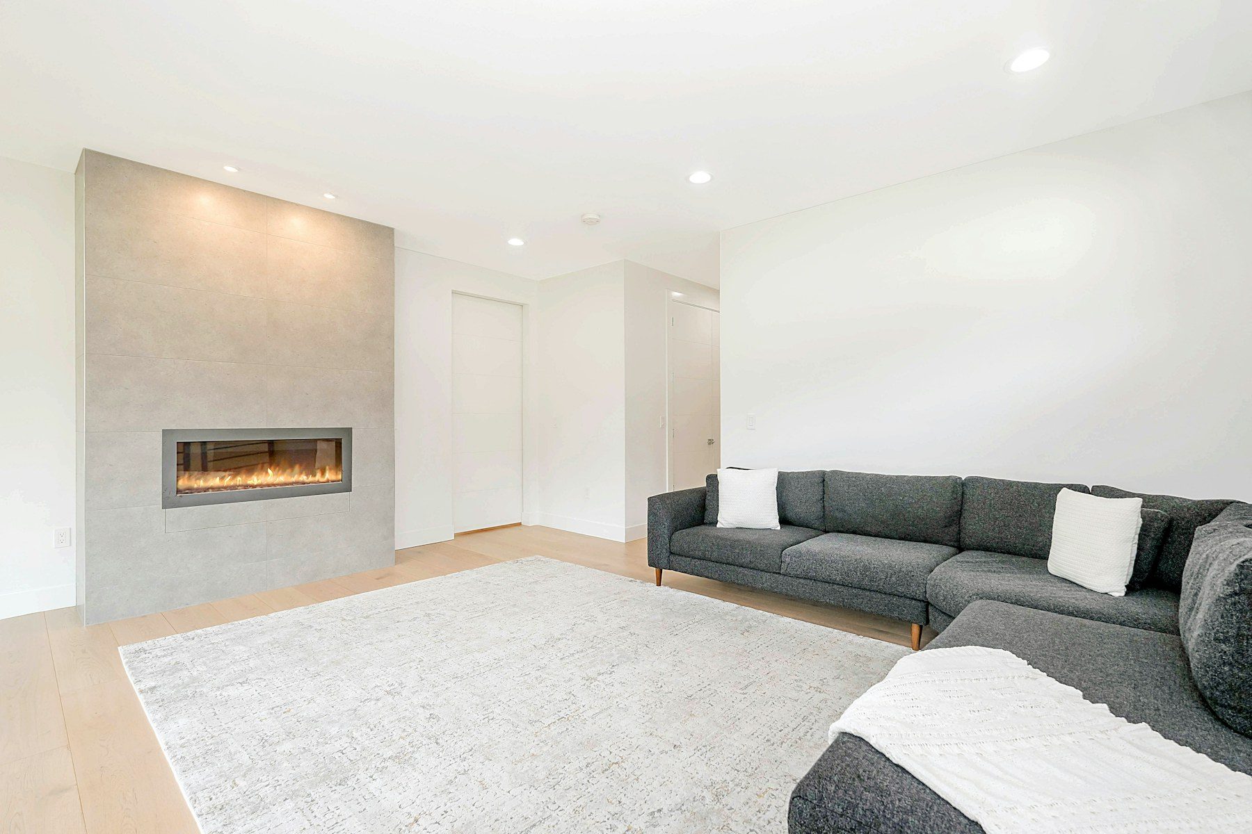 Lichte woonkamer met een brede inbouwhaard in de wand